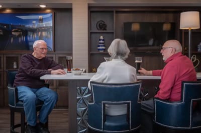 Three residents enjoying drinks in a social area