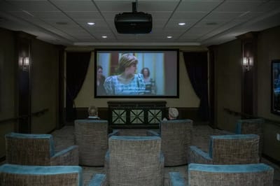 Residents watching a movie in a common area theater