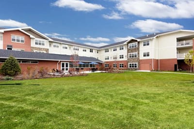 Exterior view of the facility building with lawn and patio.