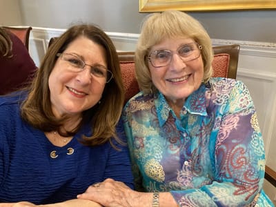 Two residents smiling together in a common area