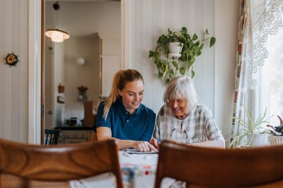 Care staff engaging with a senior resident in a bright room