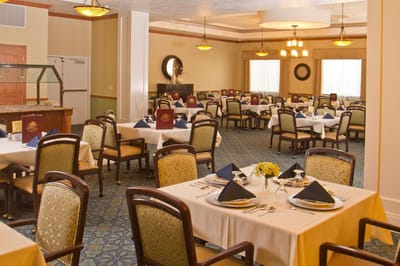 Dining room set up for a meal with tables and chairs