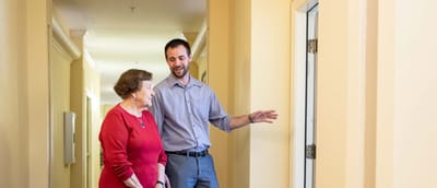 Staff member interacting with a resident in a hallway