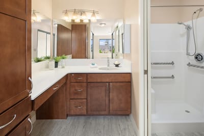 A modern bathroom with wooden cabinets and a walk-in shower