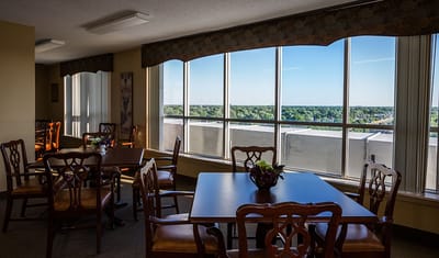 A bright common area with tables and a view