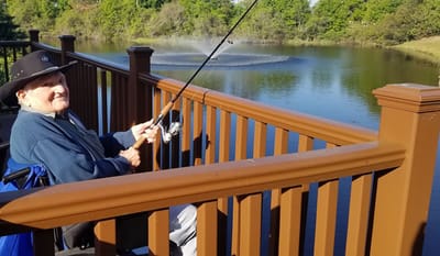 Resident fishing by a pond in a serene outdoor space