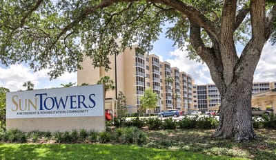 Exterior view of Sun Towers Retirement Community with signage