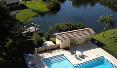 Aerial view of pool area by a lake