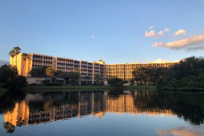 Exterior view of Sun Towers Retirement Community by a lake