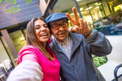 Resident and staff member smiling outdoors