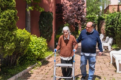 An elderly resident being assisted outdoors