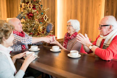 Residents celebrating with gifts in a cozy lounge