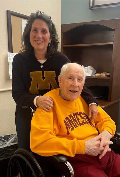 Smiling staff member with resident in a cozy interior