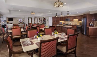 Dining area with well-set tables and kitchen visible