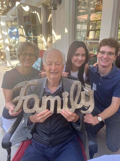 Family gathering with a resident holding a sign