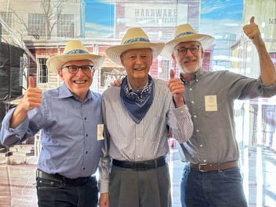Residents and staff in hats giving thumbs up