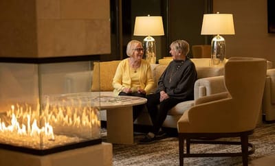 Two residents chatting in a cozy lounge area