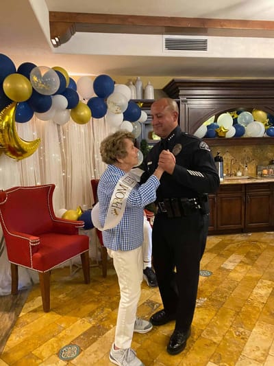 A resident dancing with a staff member at a celebration