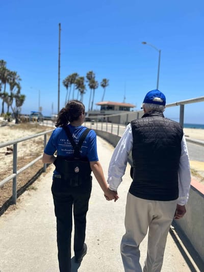 Staff member walking with a resident along a path