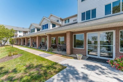 Exterior view of a senior living facility with outdoor seating