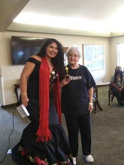 A resident and staff member at a celebration event
