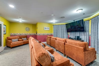 Cozy lounge area with orange couches and a TV