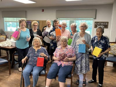 Residents participating in an activity, holding colorful bags