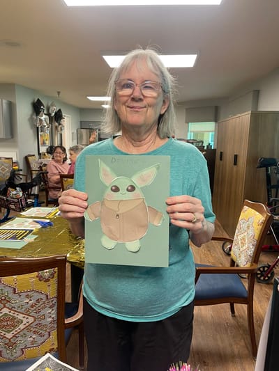 Resident proudly displaying a handmade art project