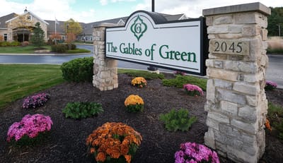Exterior sign of The Gables of Green with flowers