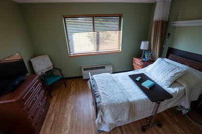 Cozy resident room with bed, TV, and window