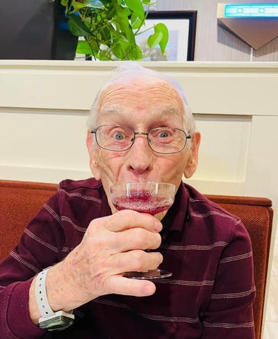Resident enjoying a drink with a joyful expression