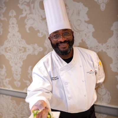 Chef presenting a dish in a dining area