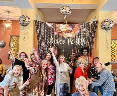 Residents and staff celebrating at a disco party