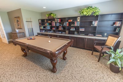 Interior view of a billiards room with bookshelf