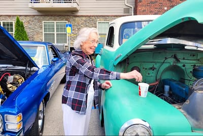 Senior resident enjoying time with a vintage car