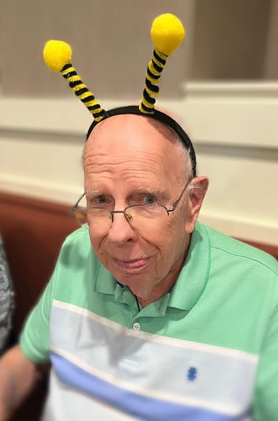 Resident with playful bee headband during an activity