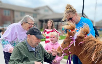 Residents interacting with a miniature horse during a visit