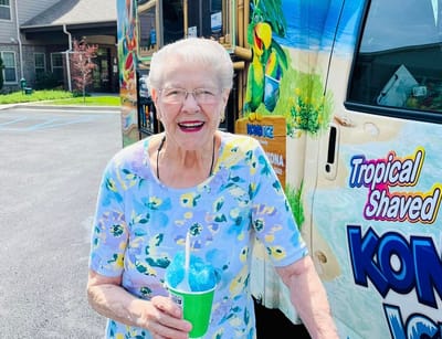 Resident enjoying a snow cone outside near the facility