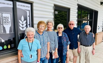Residents smiling in front of a building