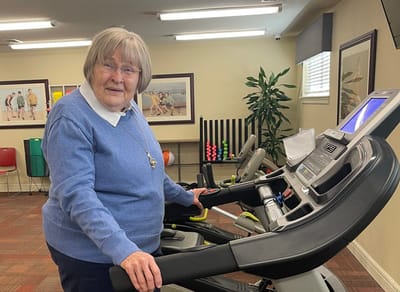 Senior resident using a exercise machine in a fitness area