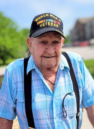 Elderly man outdoors wearing a veteran cap
