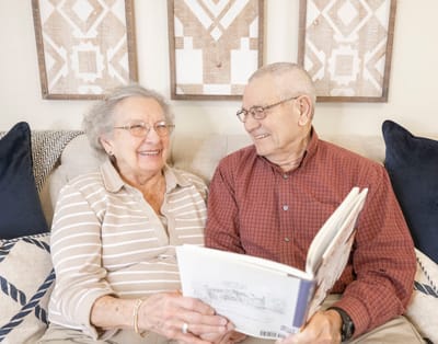 A smiling couple reading together in a cozy setting