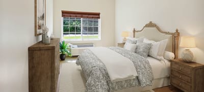 Well-decorated private resident room with bed and dresser