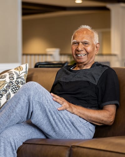 Happy resident sitting on a couch in a common area