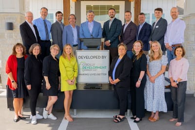 Group photo of staff members in front of the facility
