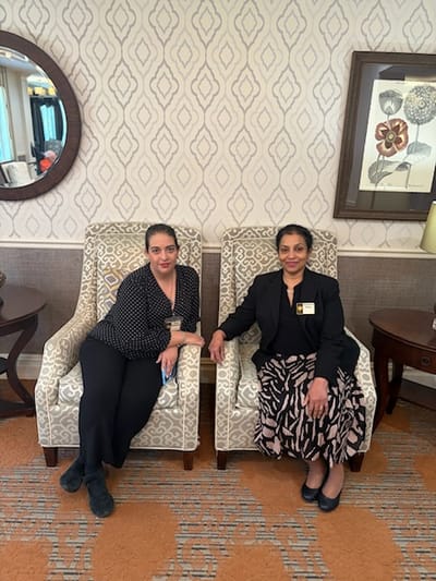 Two staff members posing in a common area
