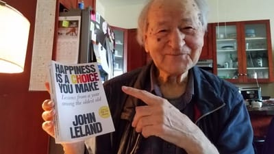 Senior resident holding a book indoors