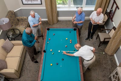 Residents playing billiards in an activity room