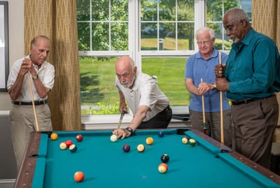Residents playing billiards in a common area
