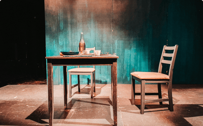 Empty dining table with two chairs on stage